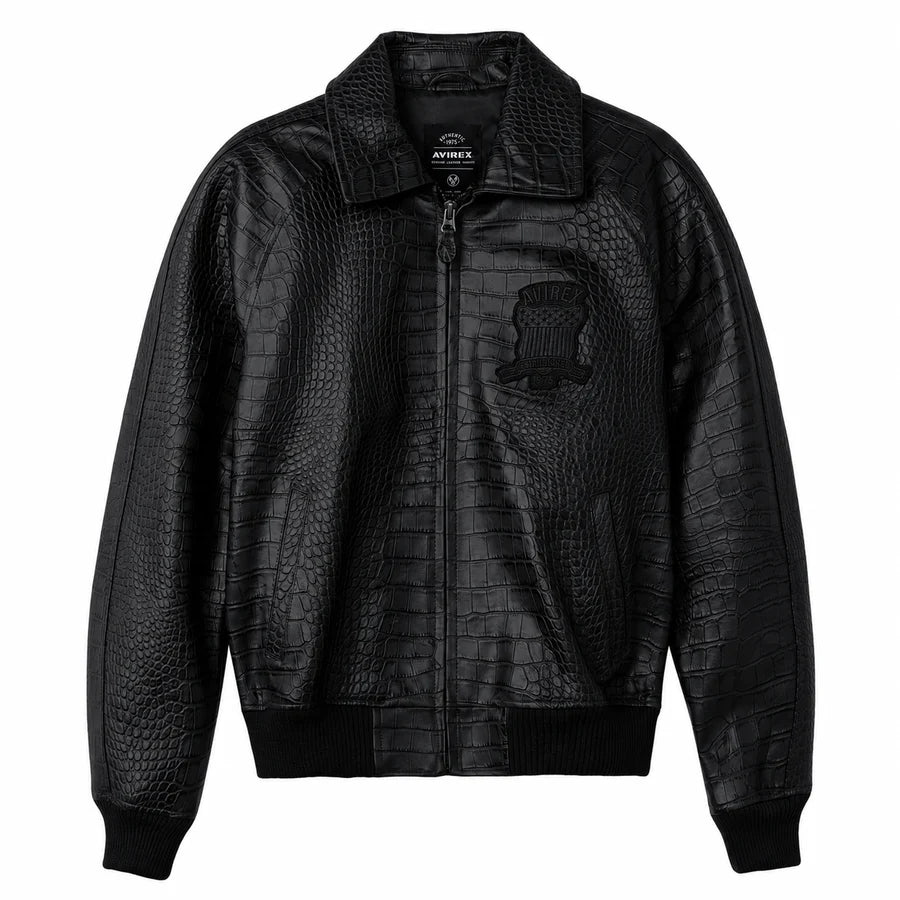 Black Avirex crocodile-texture leather jacket front view with zip closure, embroidered chest emblem and ribbed bomber cuffs on a white background.