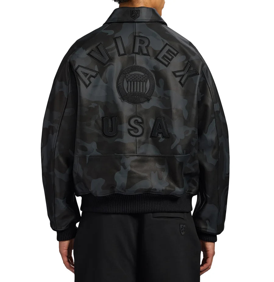 AVIREX black camo leather jacket back view with large AVIREX USA lettering, embossed emblem, dark camouflage pattern, and ribbed hem.