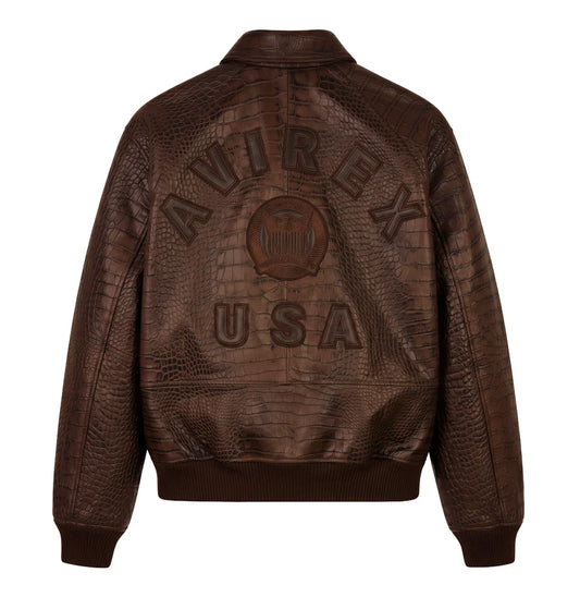Back view of a brown crocodile-effect bomber jacket on a white background, featuring large AVIREX USA lettering, a central emblem and ribbed hem.