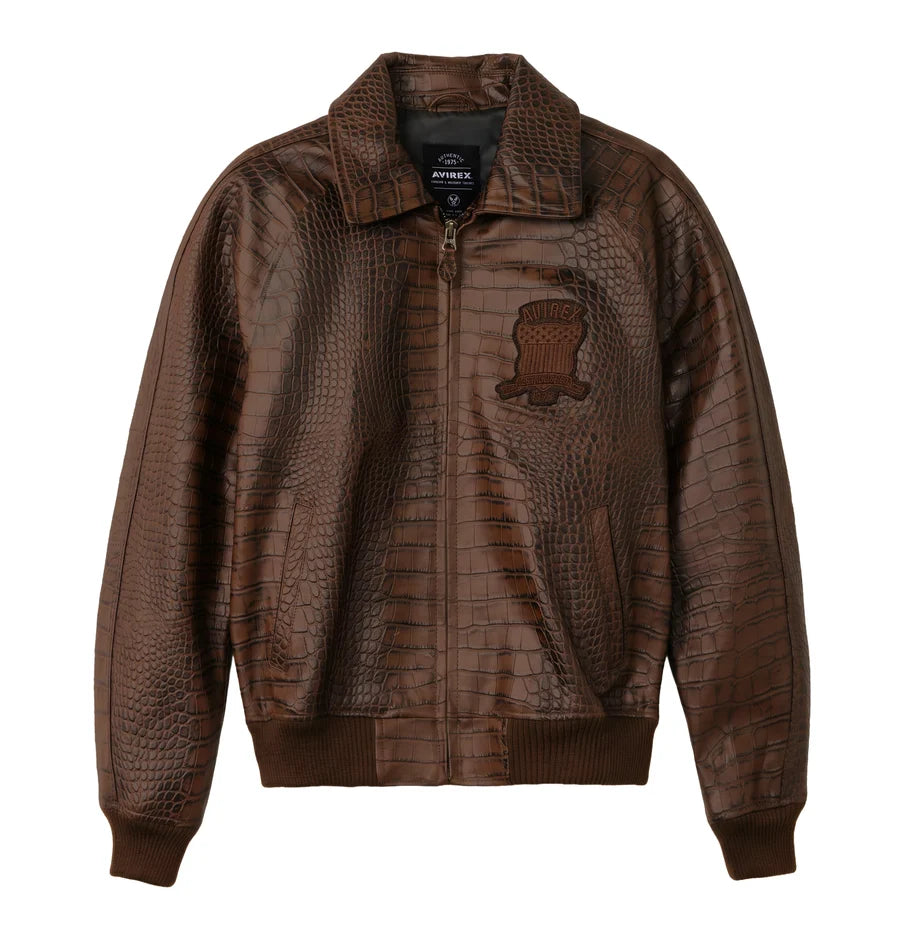 Front view of a brown crocodile-embossed bomber jacket on a white background, featuring a front zipper, textured finish, chest patch, shirt-style collar and ribbed cuffs.