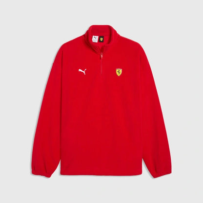 A red Puma x Scuderia Ferrari half-zip fleece pullover jacket, featuring a white Puma cat logo on the right chest and a yellow Ferrari shield logo on the left chest, displayed on a light gray background.