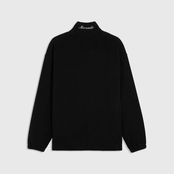 A black long-sleeve mock neck top shown from the back, featuring a small white script logo on the inside of the collar, displayed against a light gray background.