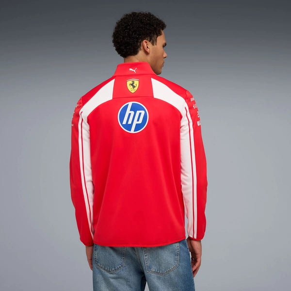 Person wearing a red sports jacket with logos on a gray background