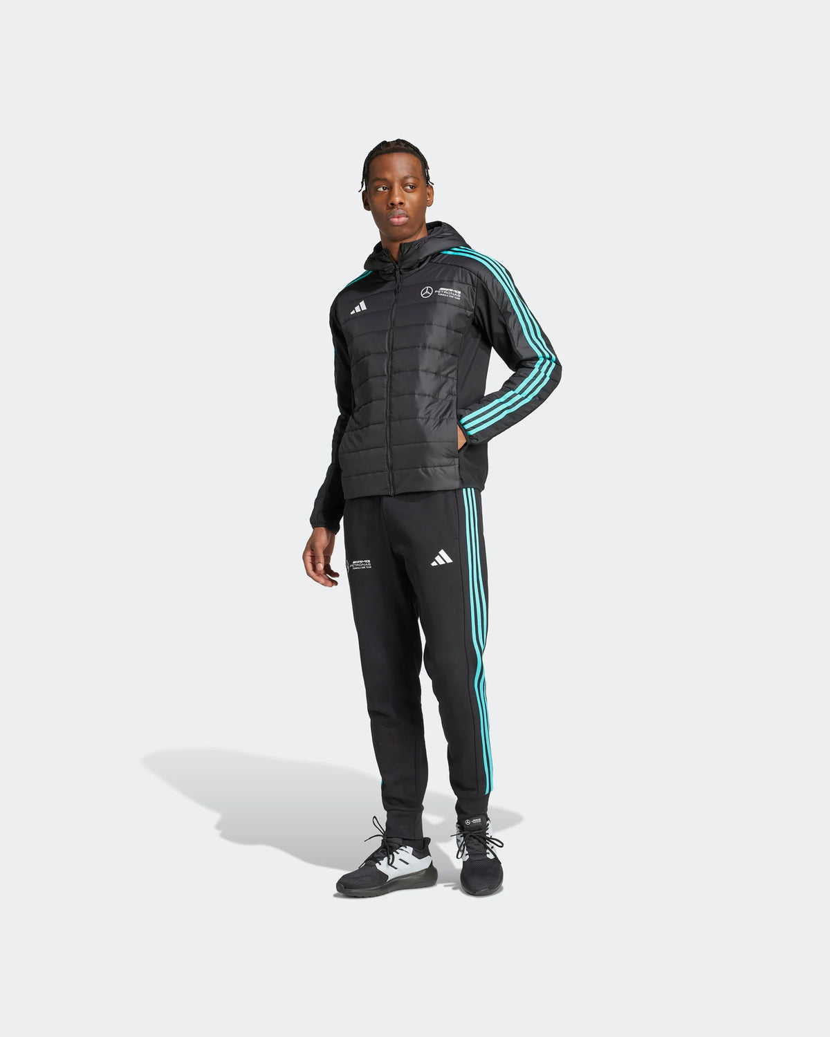 Men's black Mercedes F1 puffer jacket worn with matching motorsport tracksuit