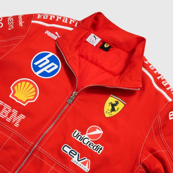 A close-up of a red Ferrari team jacket featuring white piping, sponsor logos including HP, Shell, UniCredit, and Puma, and the Scuderia Ferrari prancing horse crest.