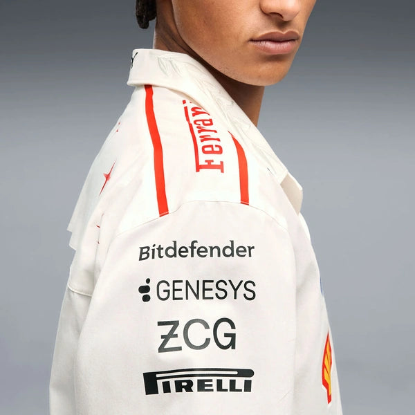 Close-up side view of a person wearing a white collared Ferrari racing shirt with red stripe details and sponsor logos including Bitdefender, Genesys, ZCG, Pirelli, and Shell.