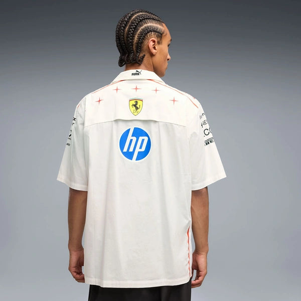 A model shown from the back wearing a white Puma Ferrari short-sleeve shirt with HP and Mercedes-Benz sponsor logos on the back, set against a gray studio background.