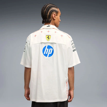 A model shown from the back wearing a white Puma Ferrari short-sleeve shirt with HP and Mercedes-Benz sponsor logos on the back, set against a gray studio background.