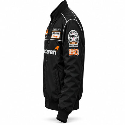 Black McLaren F1 racing jacket angled view with McLaren branding, racing patches and white contrast detailing