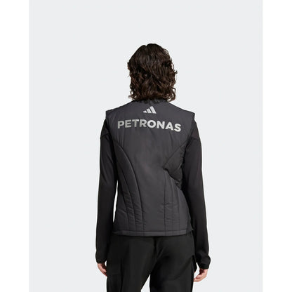 A person shown from the back wearing a black Adidas Petronas athletic jacket with white branding on the back, set against a light gray studio background.